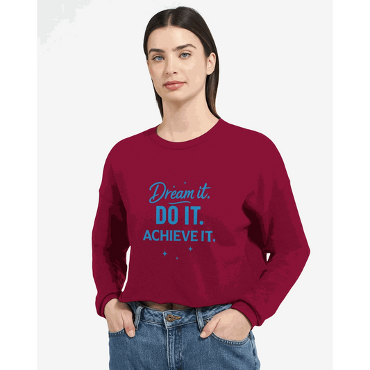 Woman wearing burgundy cropped sweatshirt with "Dream it. DO IT. ACHIEVE IT." motivational text in blue