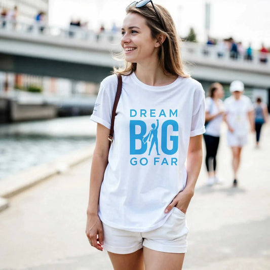 Woman wearing white Dream BIG Go Far motivational crewneck t-shirt outdoors