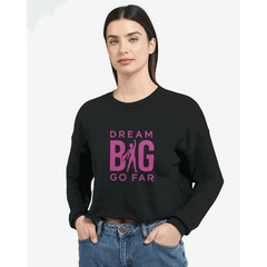 Dream BIG woman wearing black cropped sweatshirt with pink "Dream BIG Go Far" motivational text design