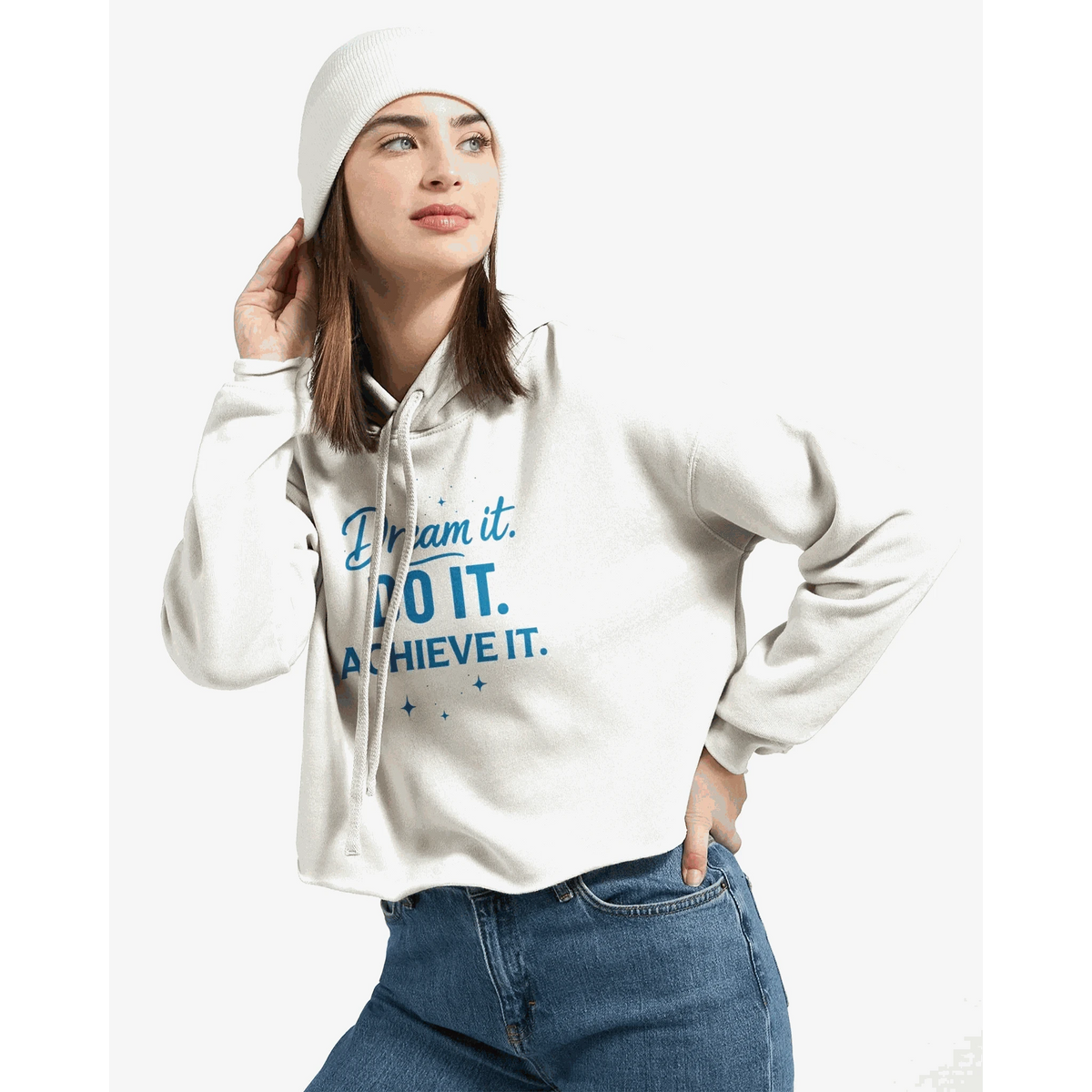 Woman wearing white cropped hoodie with "Dream it. DO IT. ACHIEVE IT." motivational text in blue and white beanie
