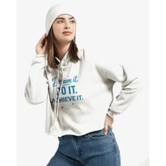 Woman wearing white cropped hoodie with "Dream it. DO IT. ACHIEVE IT." motivational text in blue and white beanie