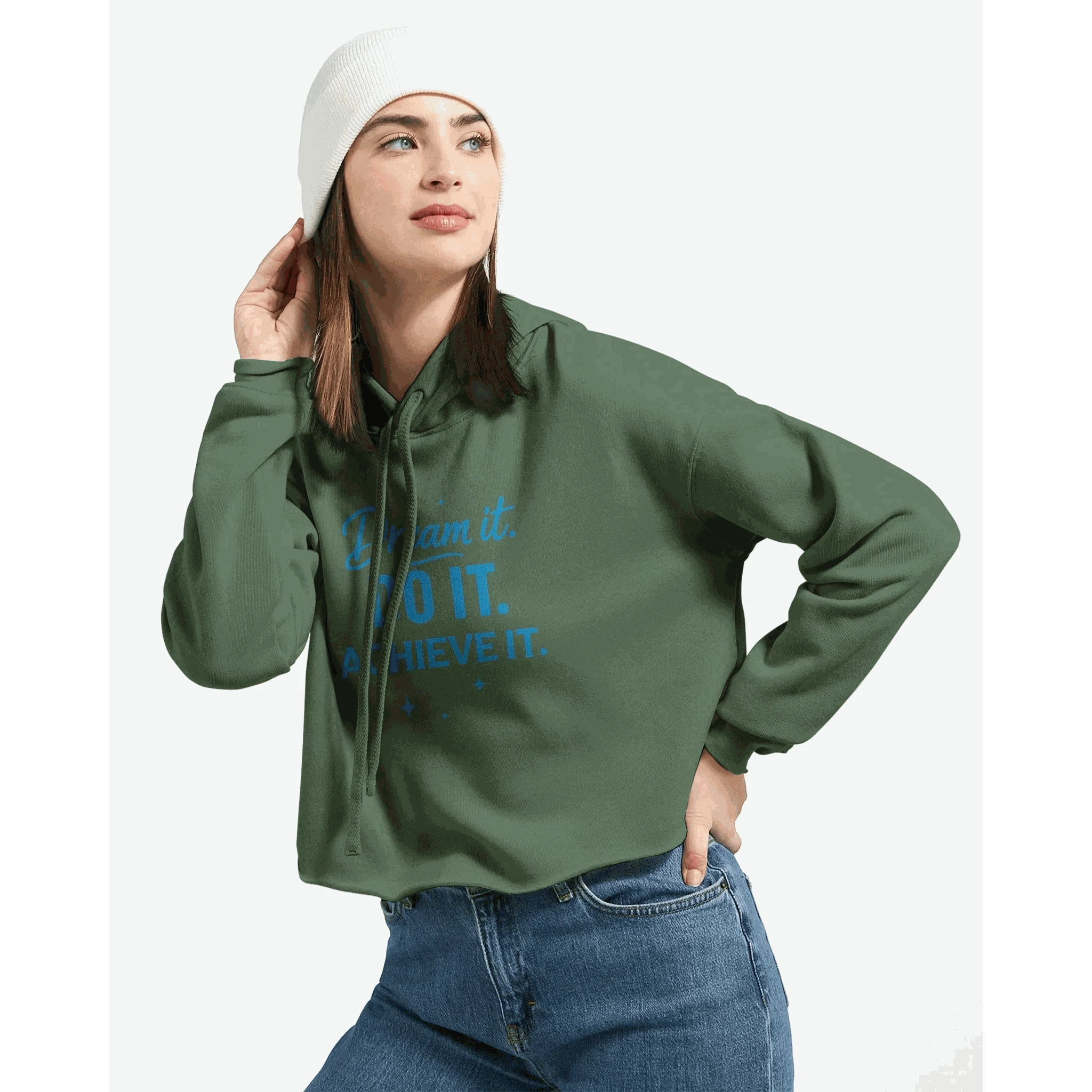 Woman wearing green cropped hoodie with "Dream It. DO IT. Achieve It." motivational text, paired with white beanie and jeans
